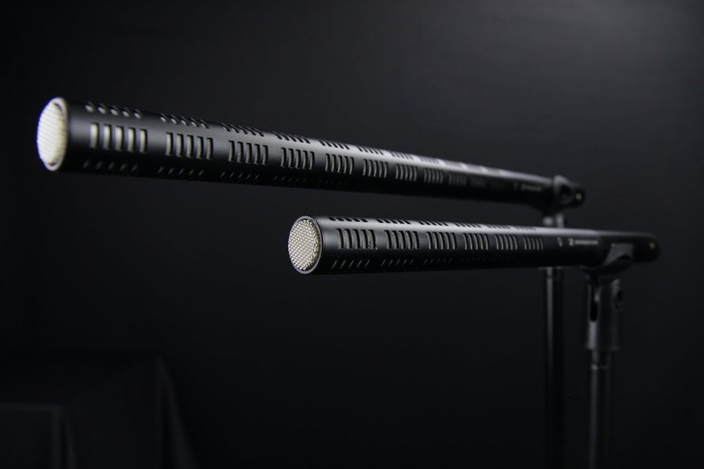 Close-up view of two professional shotgun microphones in a recording studio.